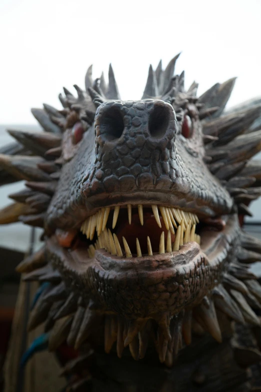 a close up po of a toothy dragon's head