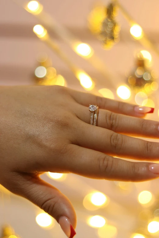 a person with a wedding ring sitting in front of some lights