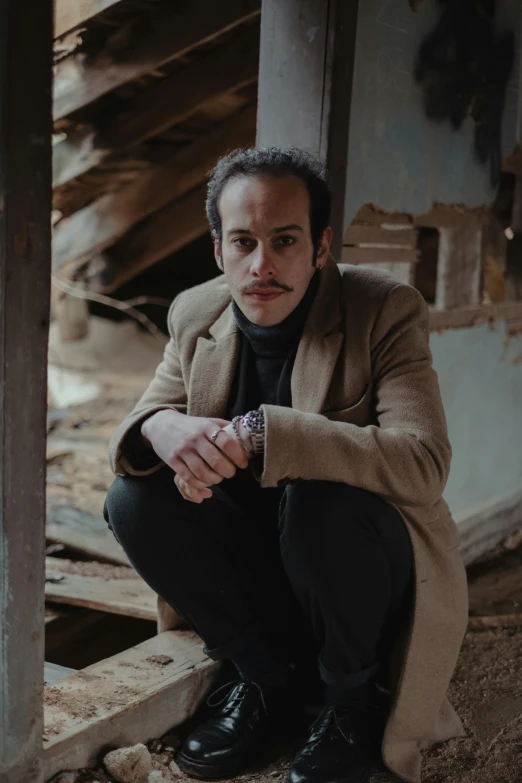 a man sitting and posing in front of the rubble