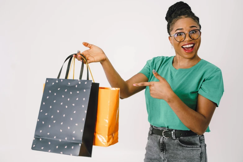 a woman holding a pair of black glasses and an orange bag