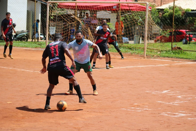 three men playing a game of soccer on the field