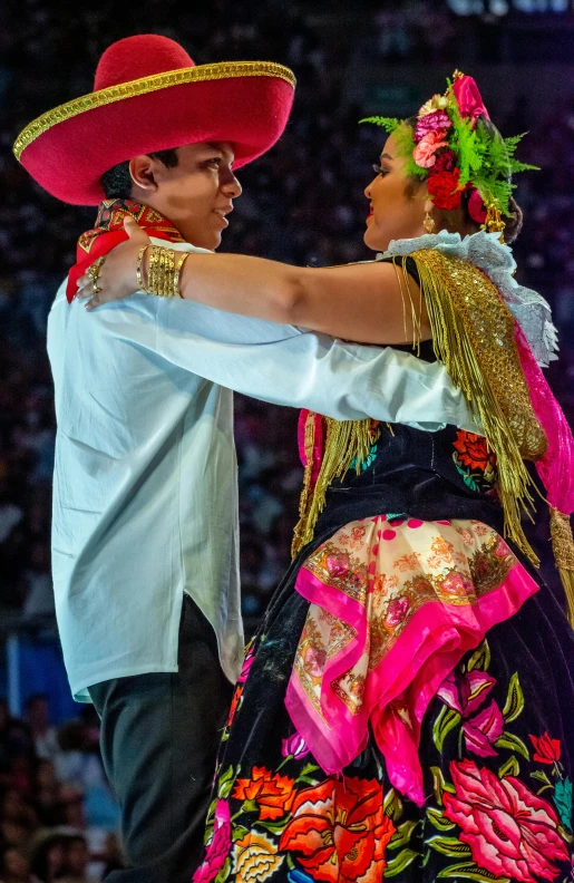 two dancers pose during a show with a crowd