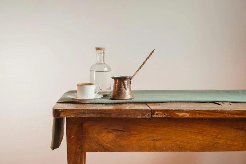 a brown table with a silver mug and a bottle sitting on top