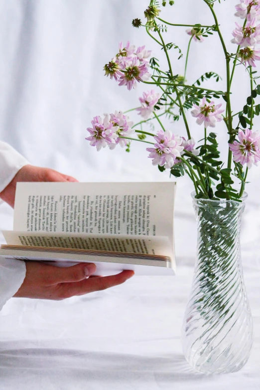 flowers in a vase holding an open book