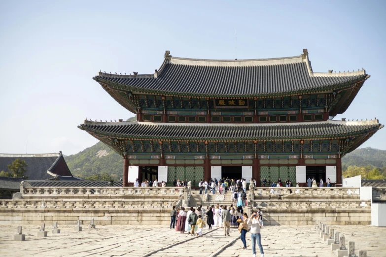 people walk near an asian building with many steps