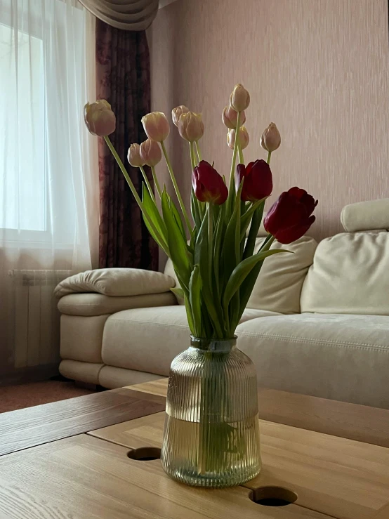 the flowers are sitting in a vase on a wooden table