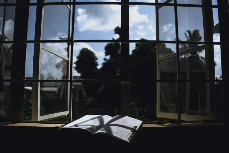 an open book sitting in front of a window