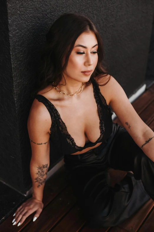 a woman with tattoos on her arm leaning against a wall