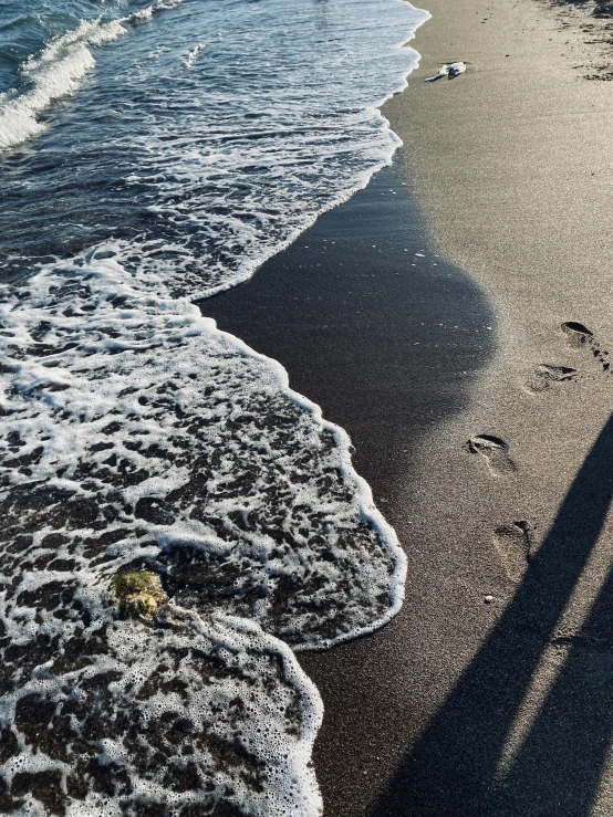 a person walking on the sand of an ocean beach