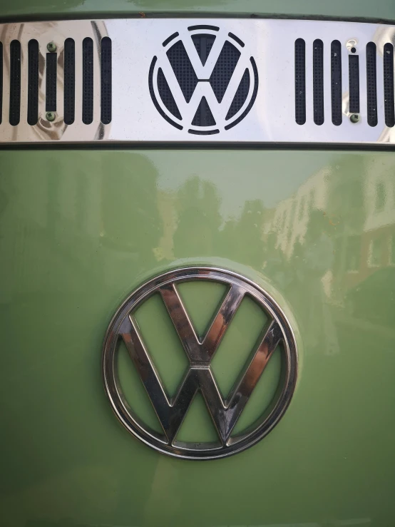 a close up of the vw emblem on a green car