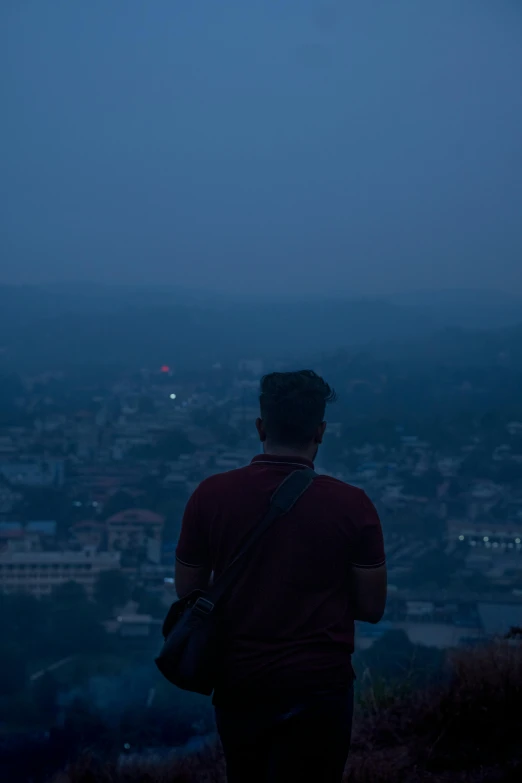 a man on top of a hill looking out into the distance