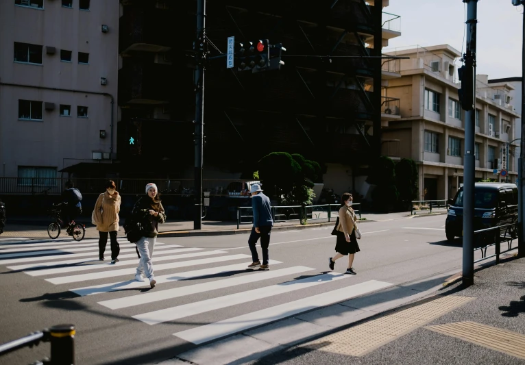 a group of people crossing the street at a cross walk