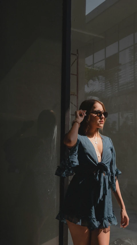 a woman in a blue shirt and shorts posing