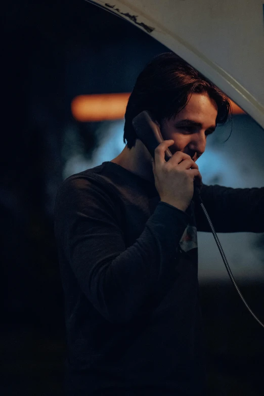 a man talking on his phone while holding a camera