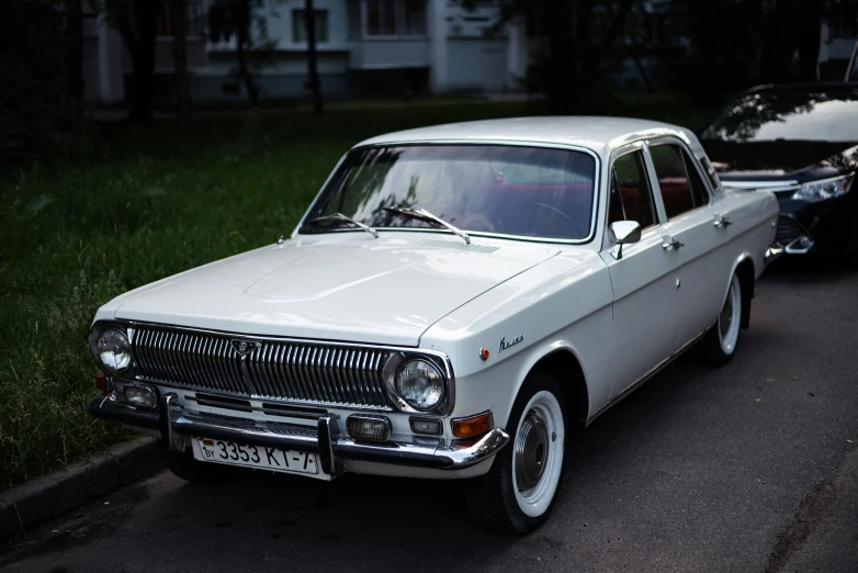 a classic white car parked on the side of a road