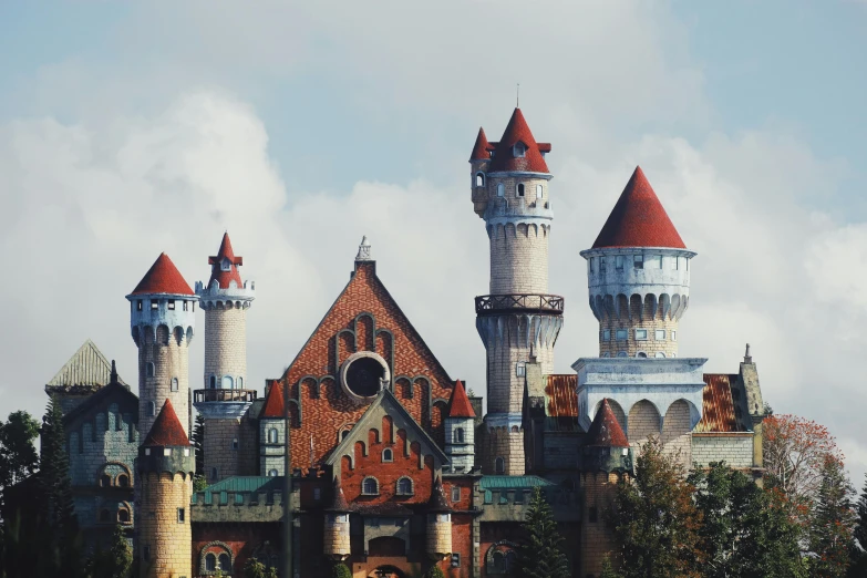 a red and white castle sitting on top of a lush green forest