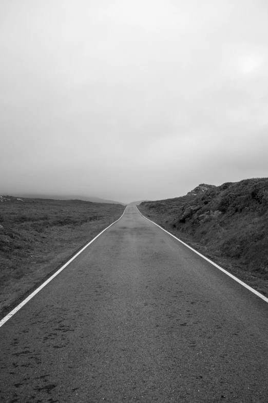 a road stretches along a hill on an overcast day