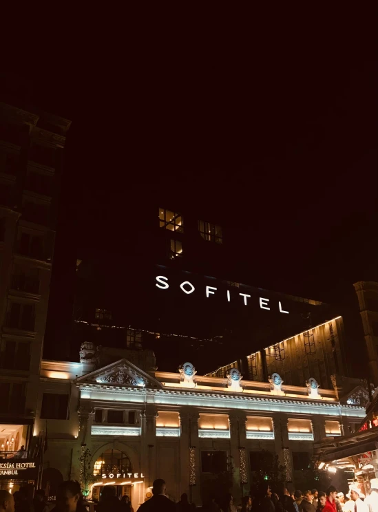 a large lit up city building sitting in front of a sign