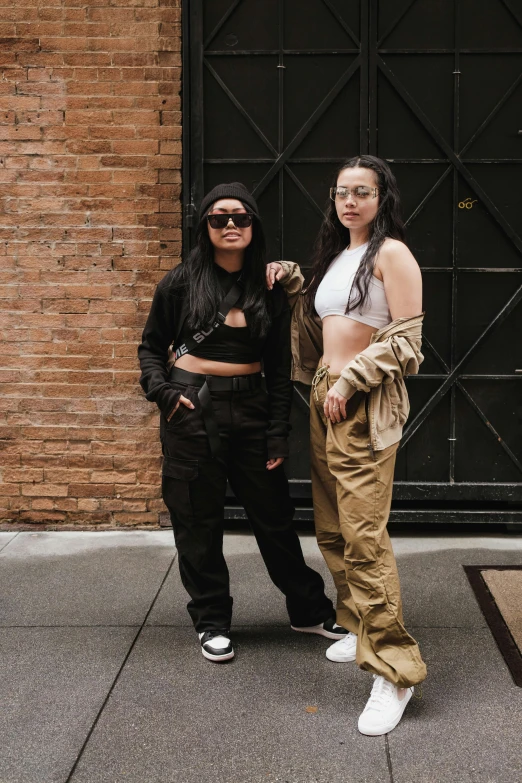 two young women standing on the street next to each other