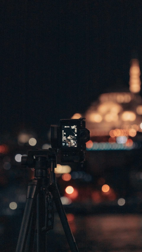 a city street seen at night from a hill top with an electronic camera