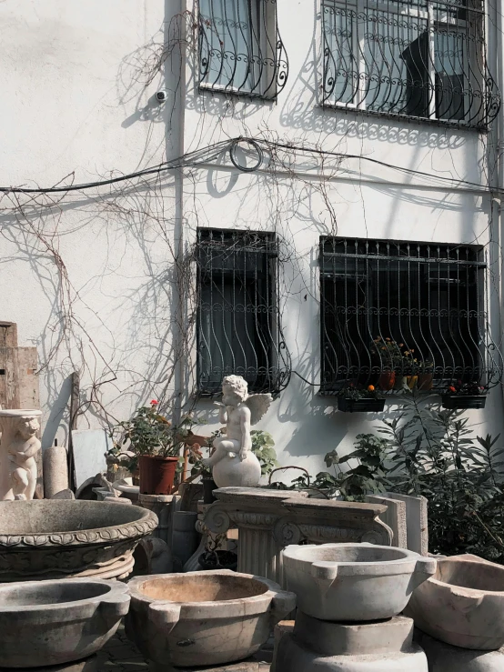 several white and gray vases and plants near windows