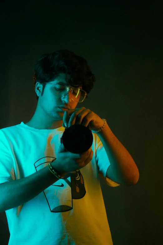 a young man wearing glasses while looking at a piece of equipment