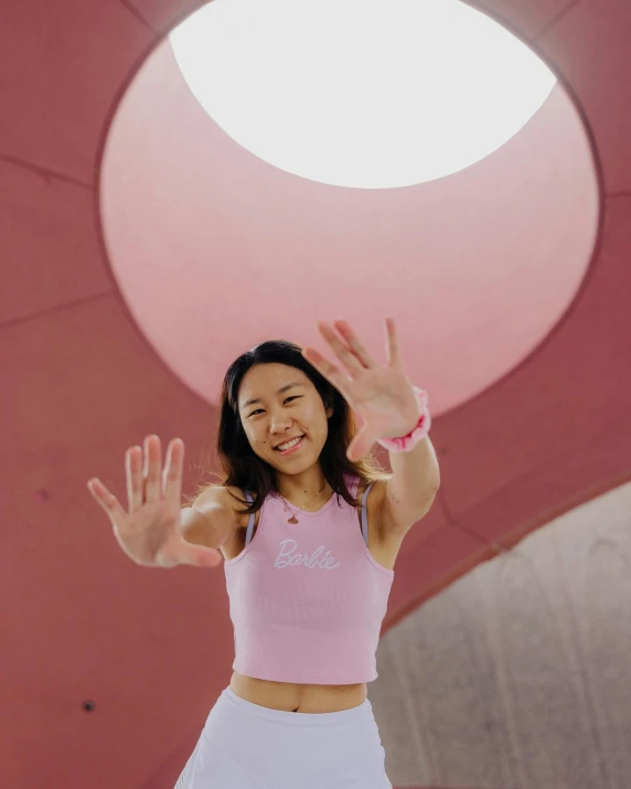 a woman standing outside with her hands in the air