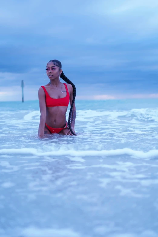 a woman in the ocean with her hair in a ponytail