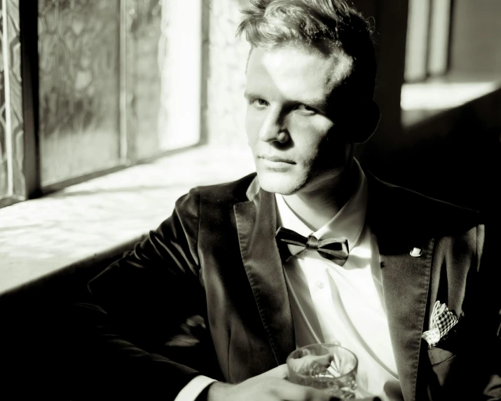 a man in a suit with a glass on his lap