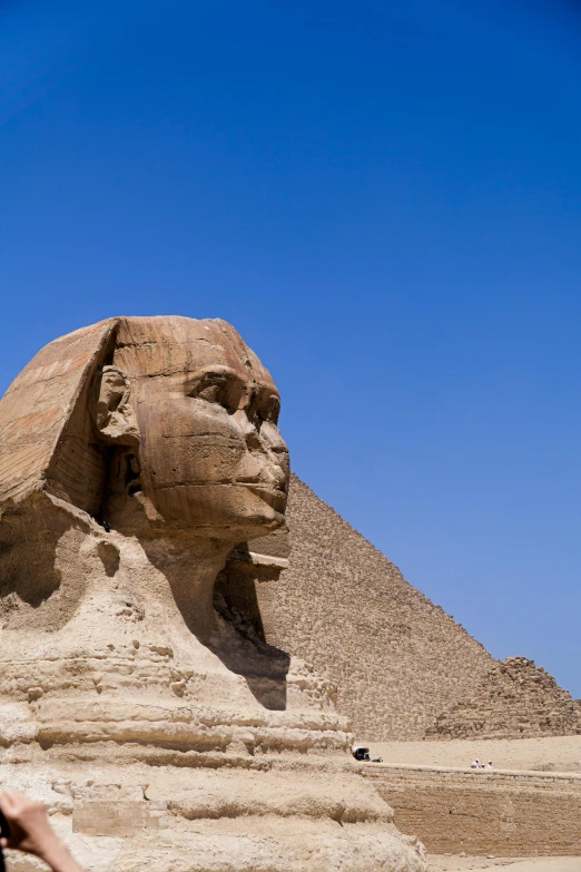 a woman takes a picture of some ancient sphinxs