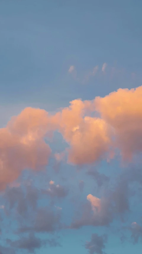 the airplane is flying in the sky at dusk