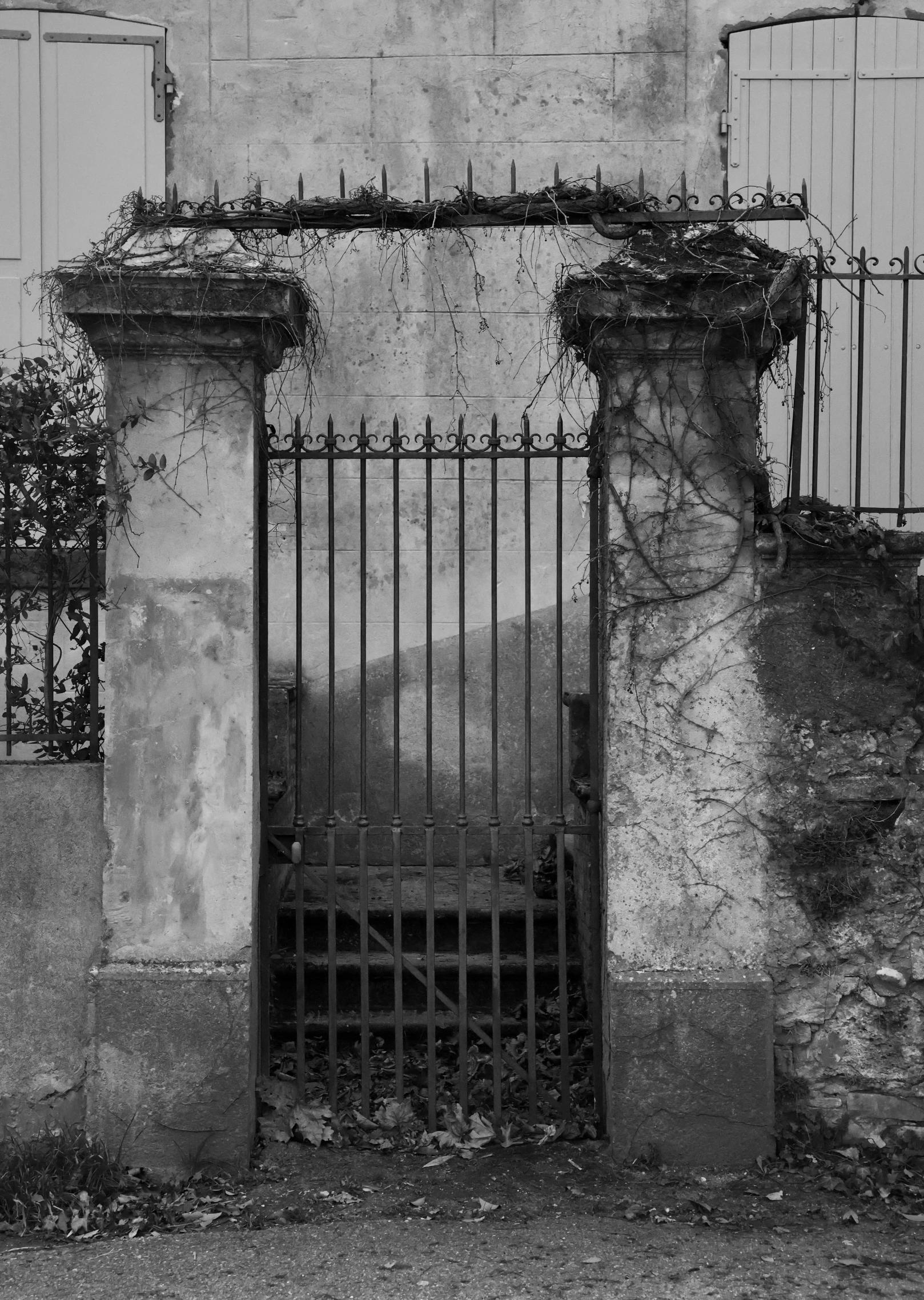 an old building with a stone wall and a gate at the top