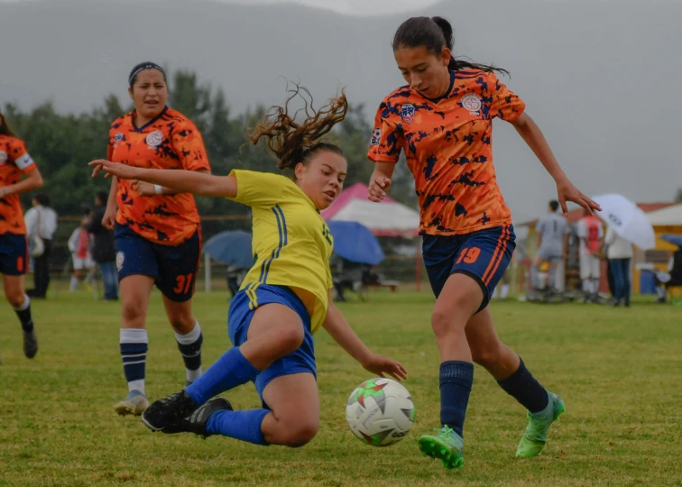 two women playing soccer, one attempting to get the ball