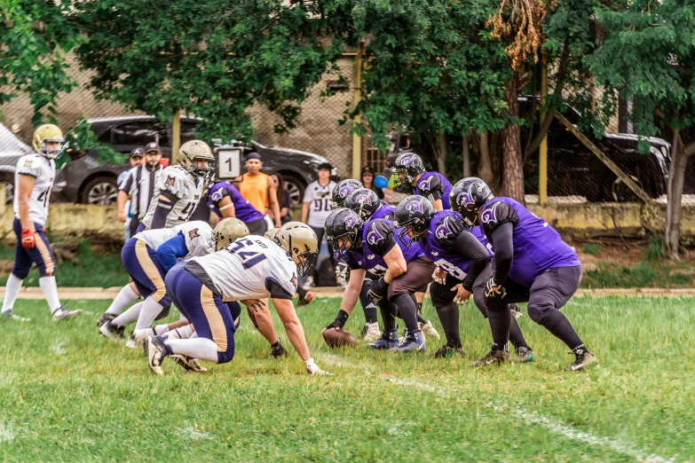 a football game being played on the field with a player getting tackled