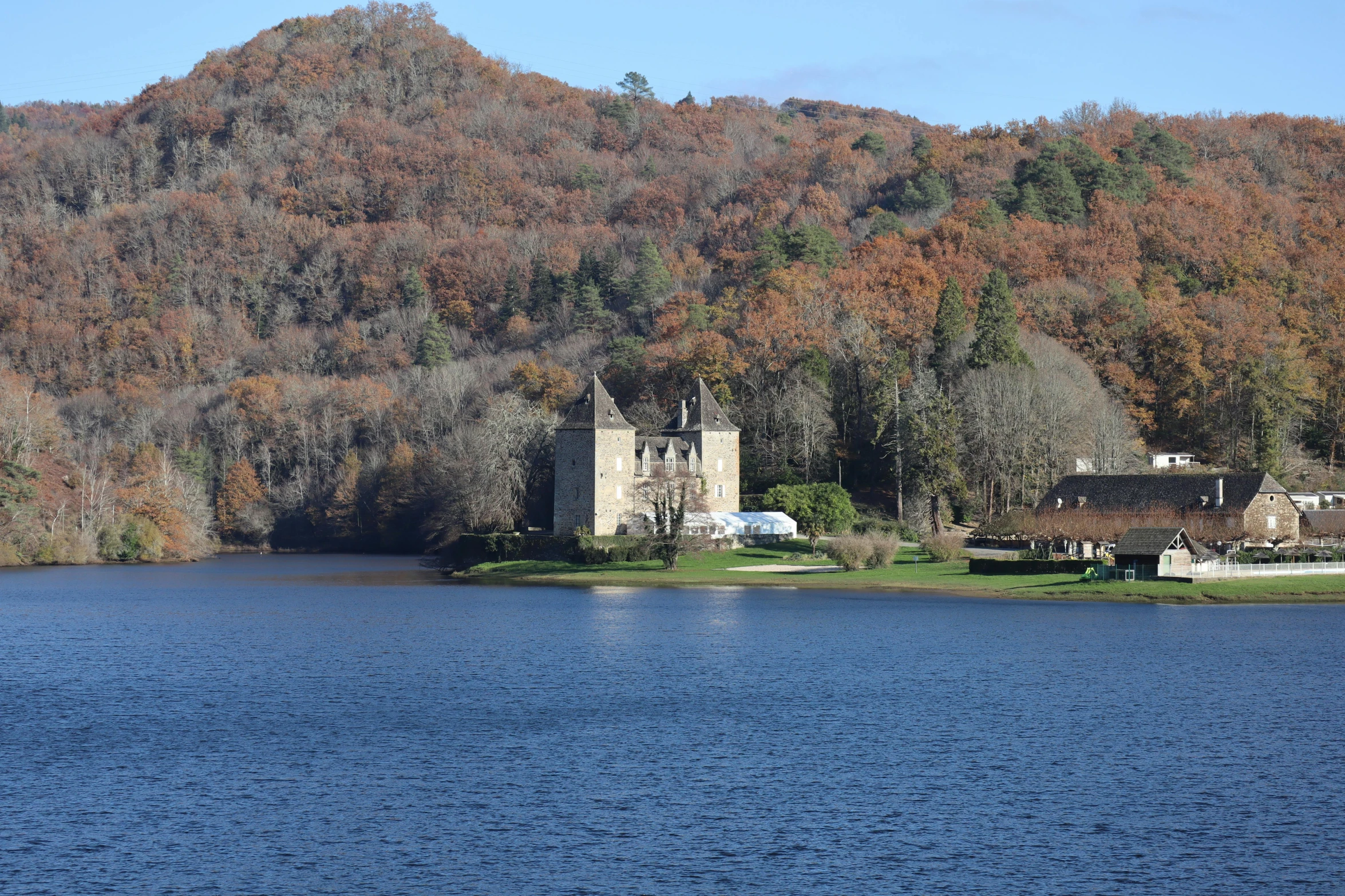 a church is nestled between two large mountains in a blue lake