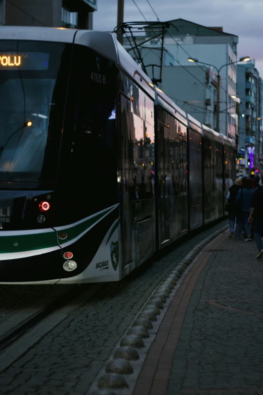 people walking on the sidewalk next to a train