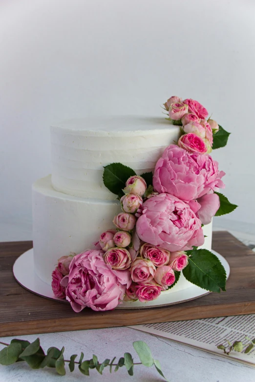 a three layer wedding cake with flowers on it