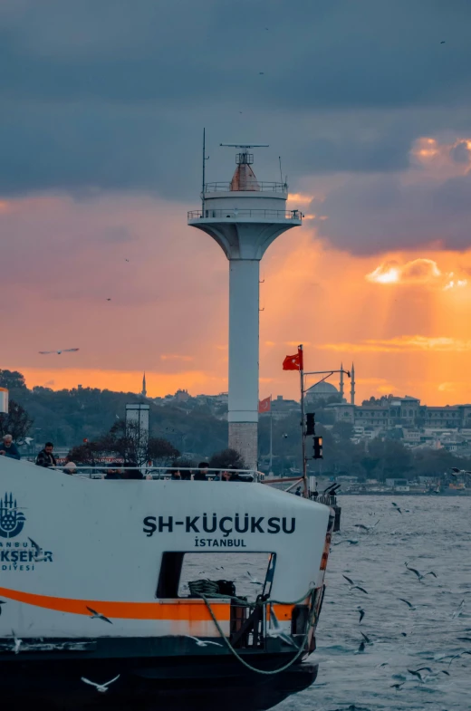 a ferry sailing away from a light tower