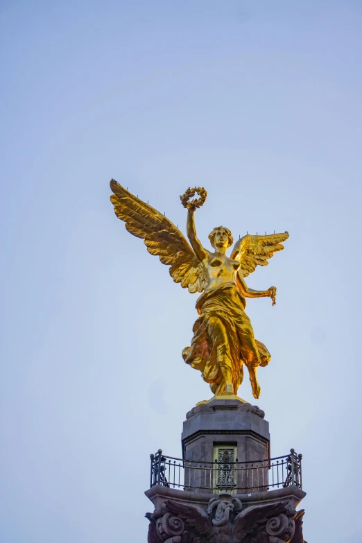 a gold angel statue on top of a building