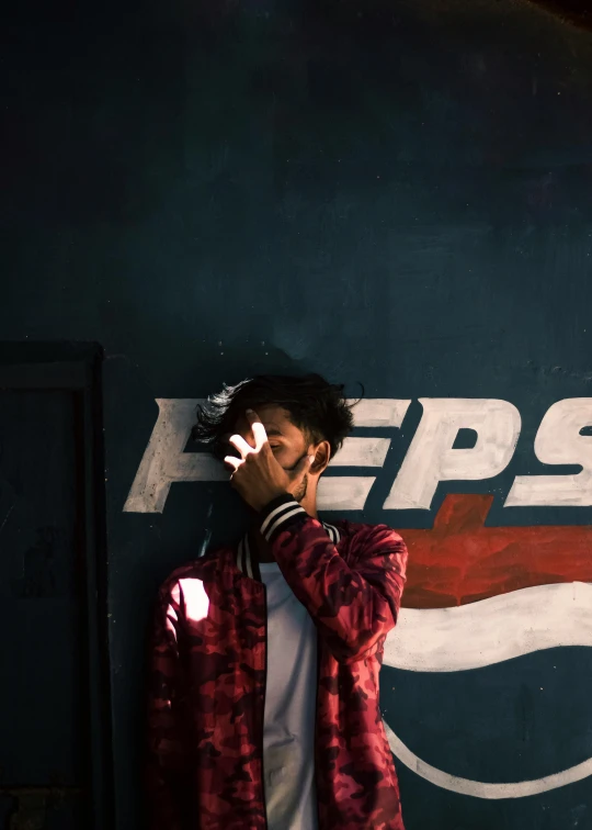 a man standing next to a pepsi sign