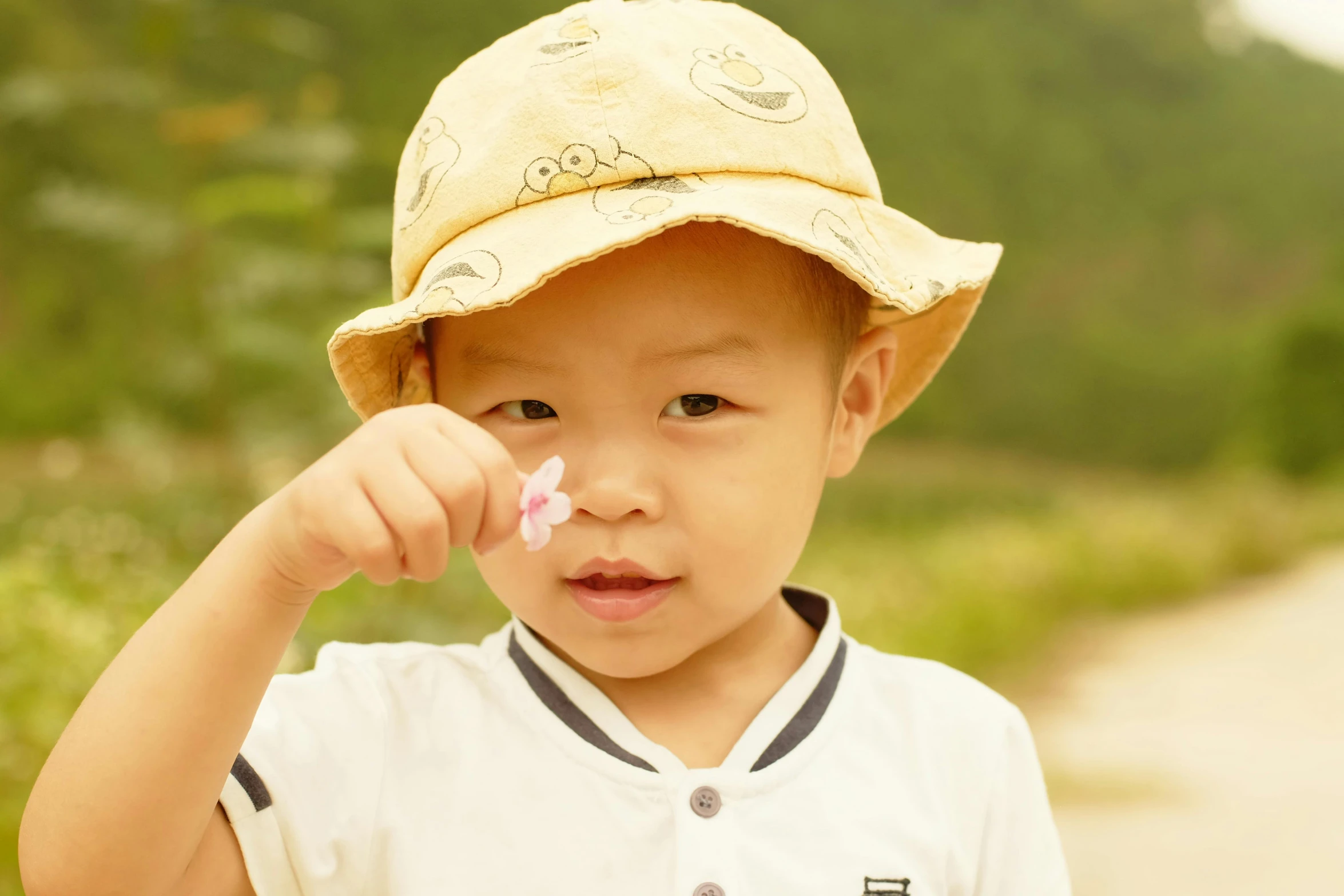 a small  wearing a baseball cap and holding a toothbrush