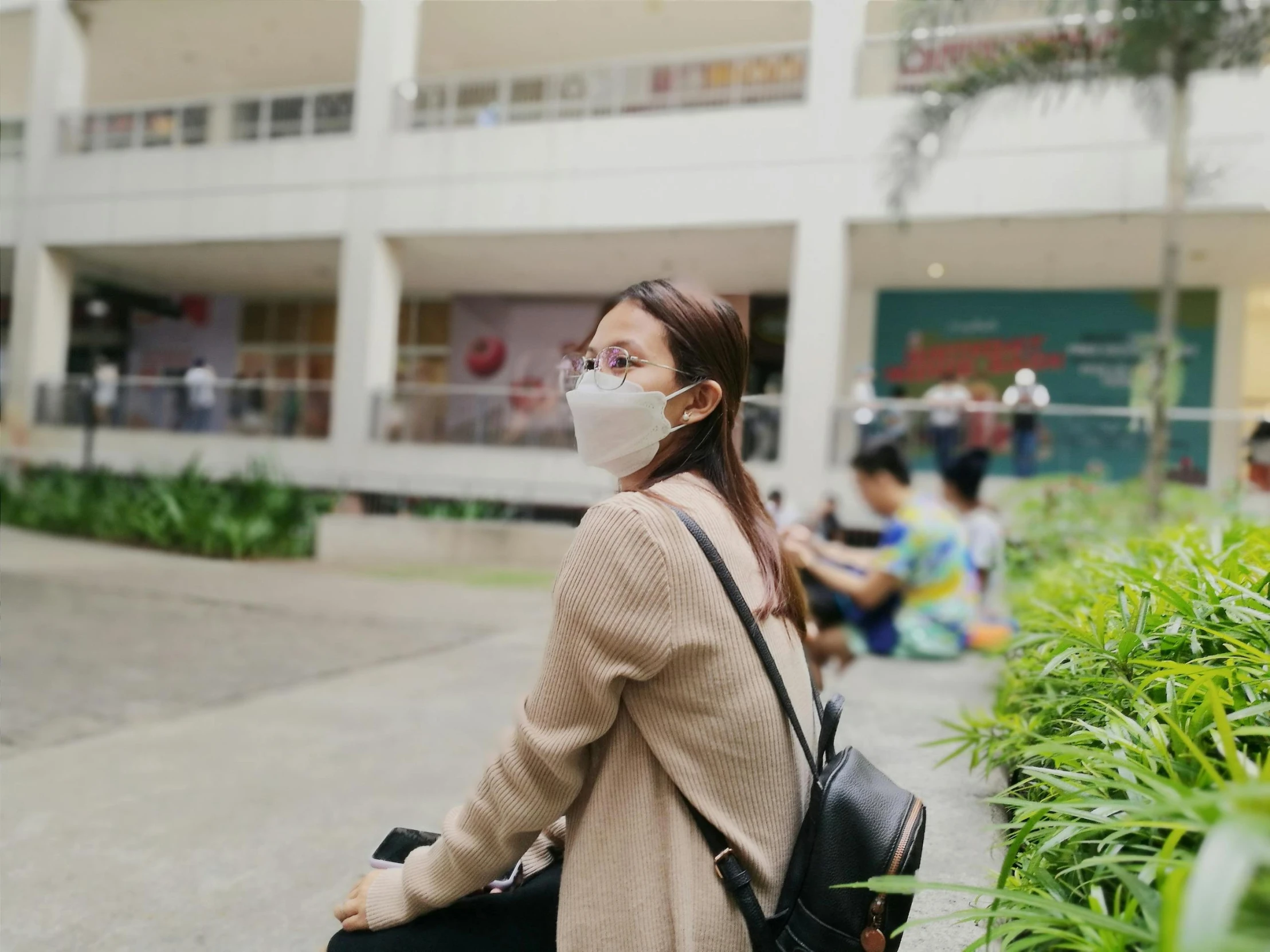 an asian woman wearing a mask walking down the street