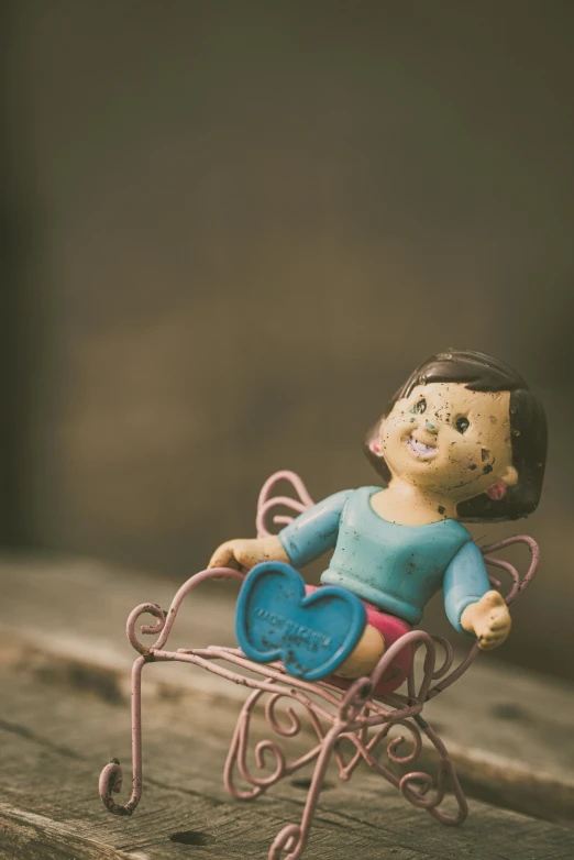 a toy girl that is sitting on a toy sleigh