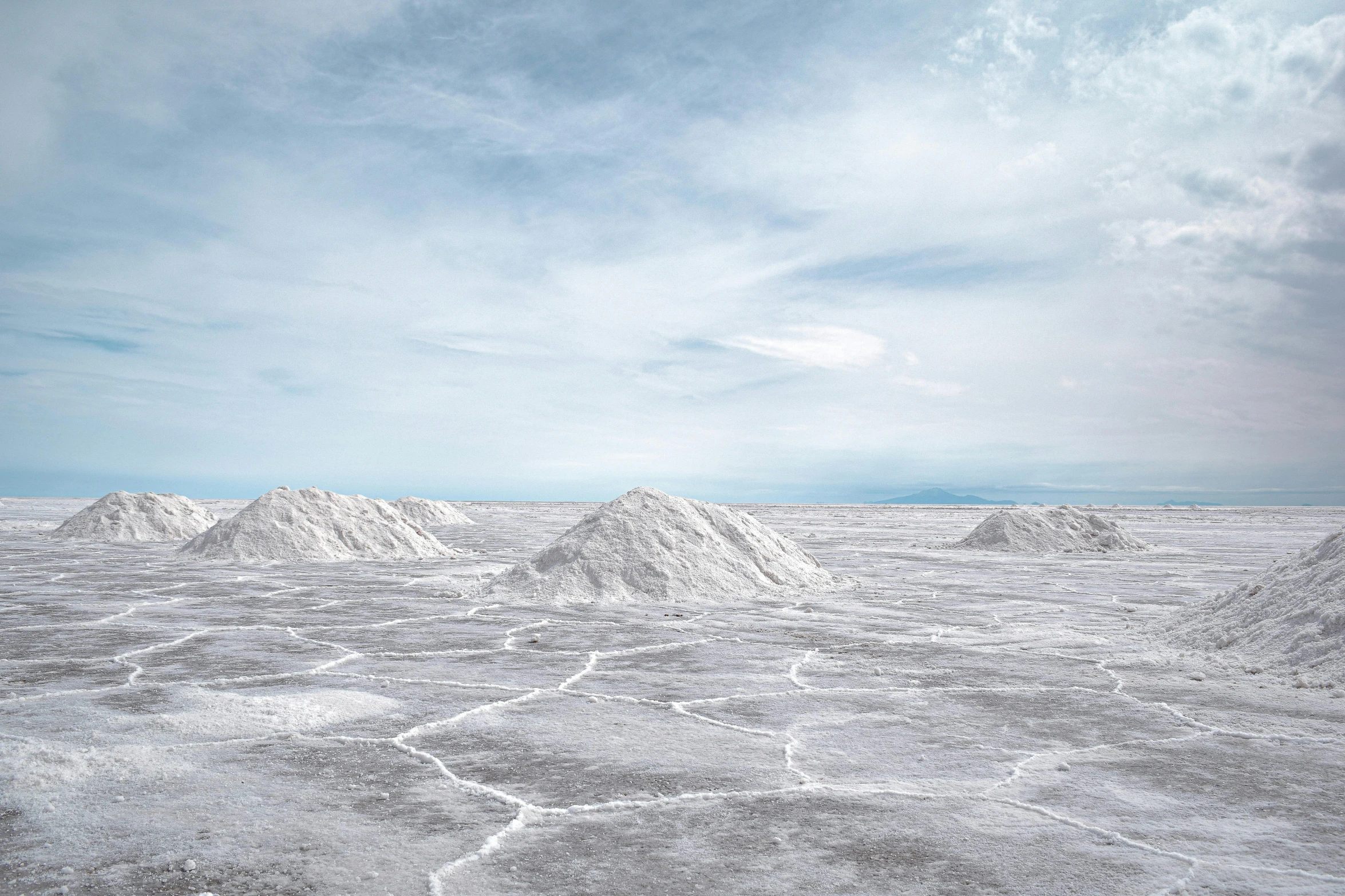 a snow covered field is surrounded by clouds