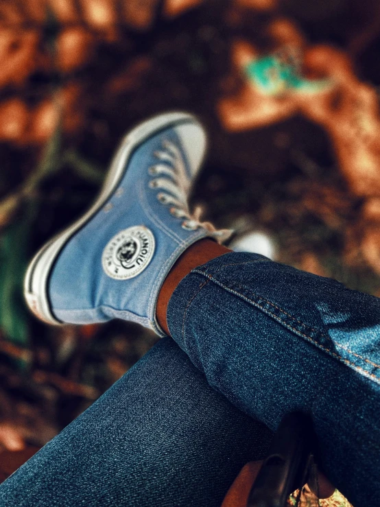 person wearing blue denim jeans and a white lace sneakers