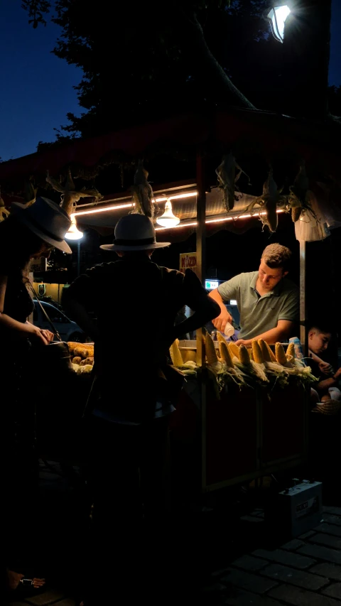 people at an outdoor market looking at their phones