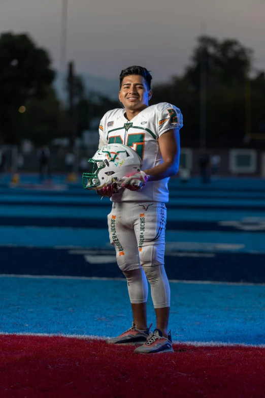 man in white football uniform posing for po