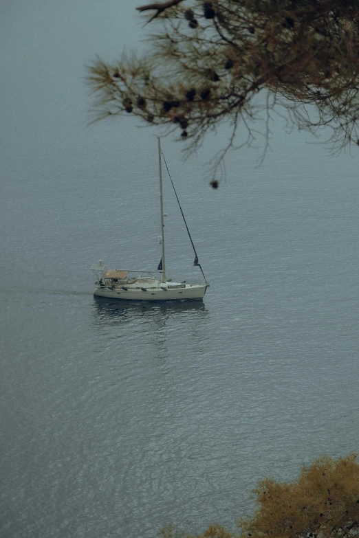 a sail boat sitting in the middle of a body of water