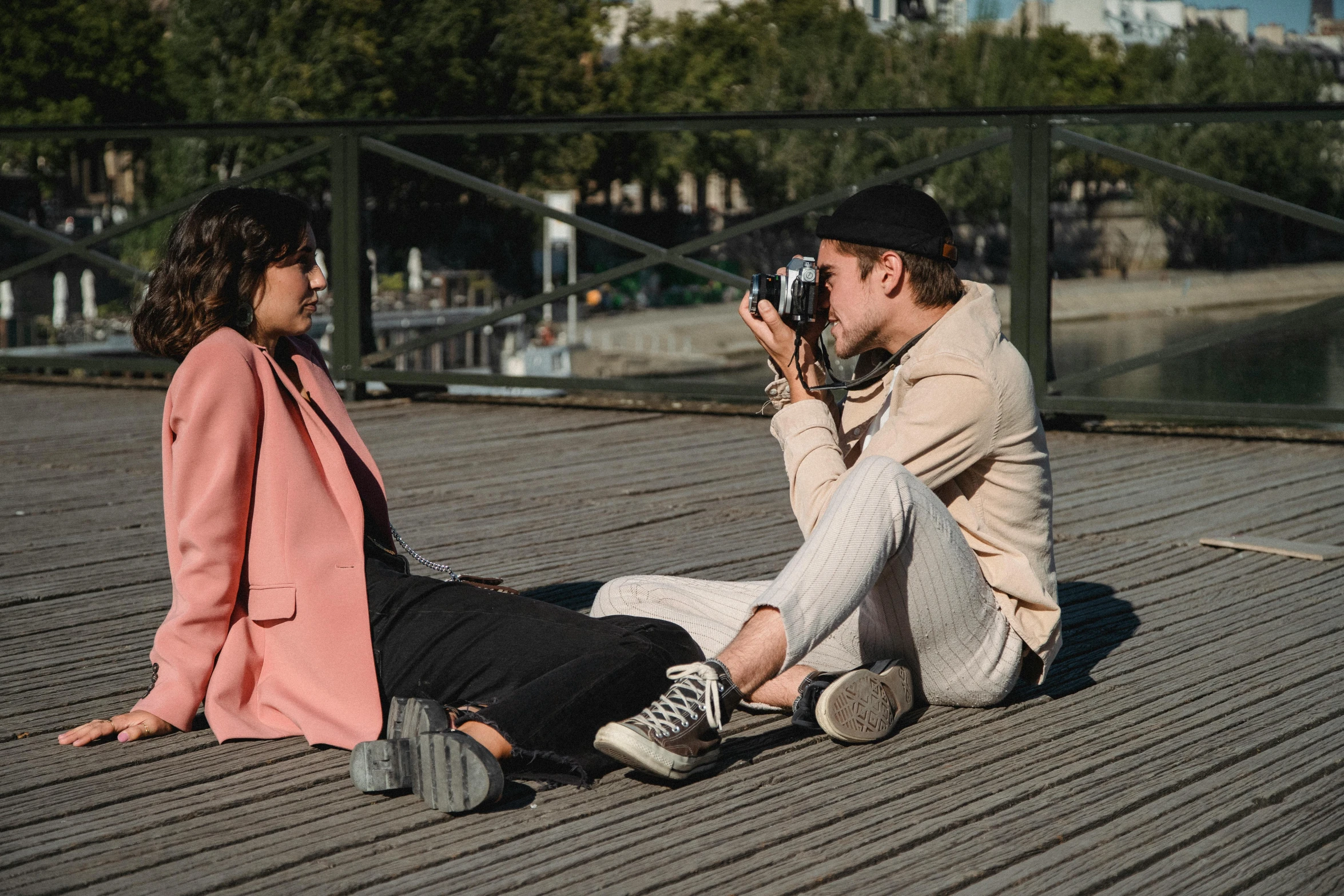 a couple sitting on the ground taking pictures