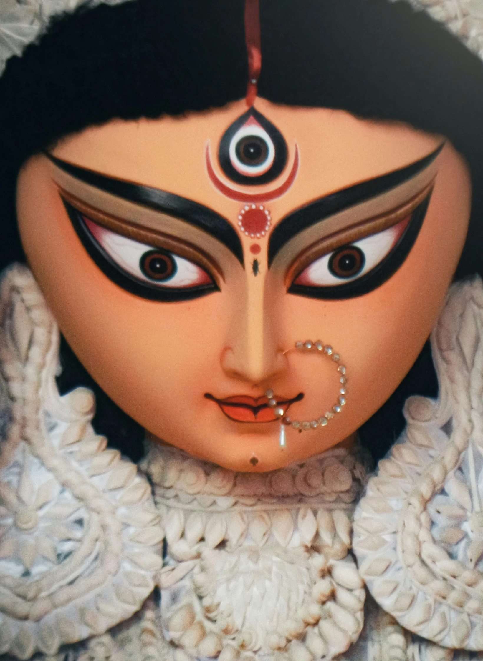 a close up of an indian mask with an eye and nose ring